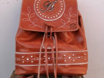 Mochila marrón con inicial y detalles en blanco