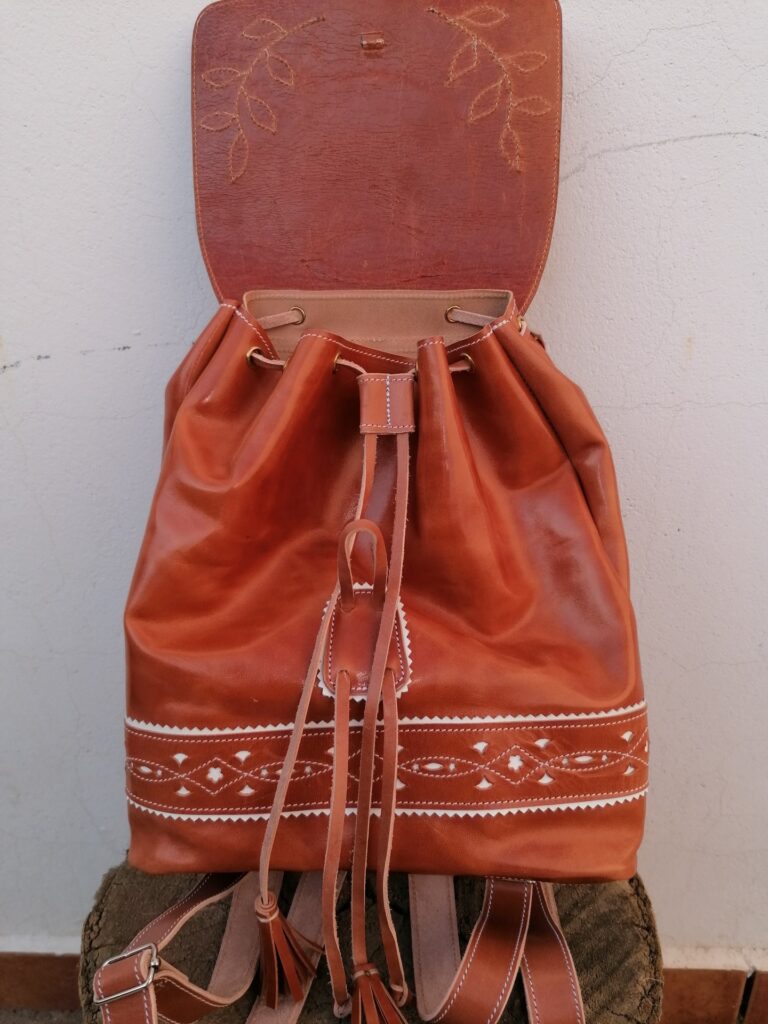 Mochila marrón con inicial y detalles en blanco